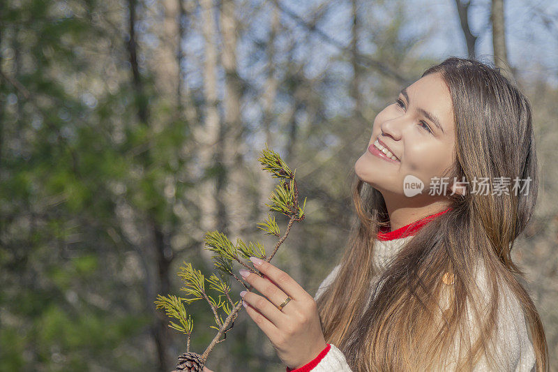 一个寒冷的感恩节/圣诞节秋天的早晨/下午，一位年轻的拉丁妇女在松冠森林中间休息时的画像。